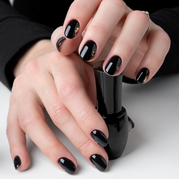 Short black nails with small gold accents.
