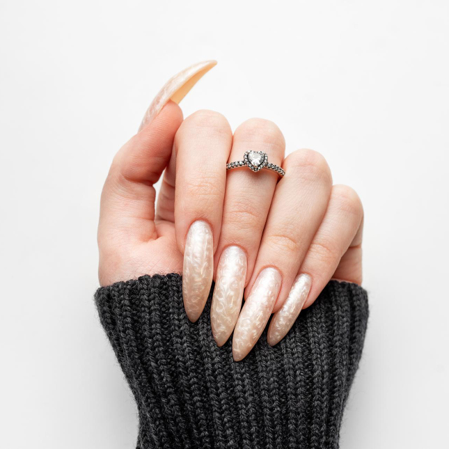 Long pointed nails with a pale shimmering finish.