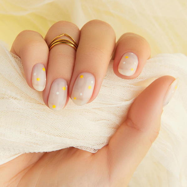 Sheer nude nails with tiny yellow and white dots.