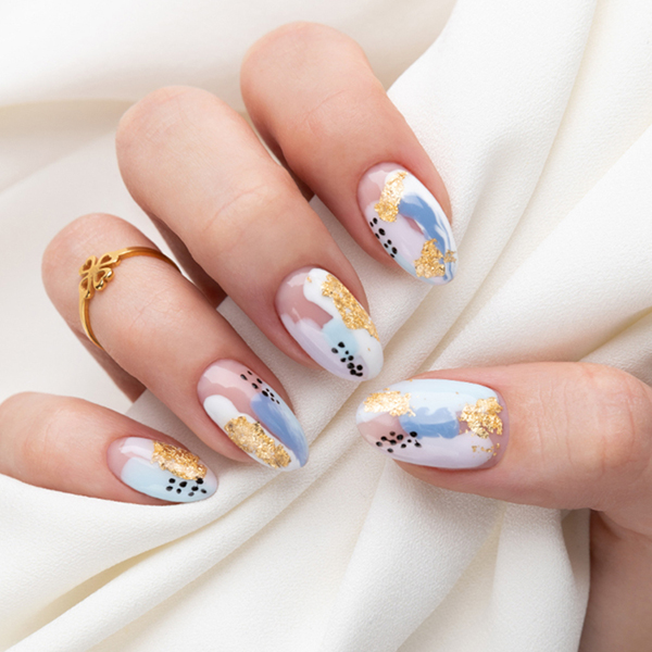 Pastel abstract nail art with gold foil and black dots.