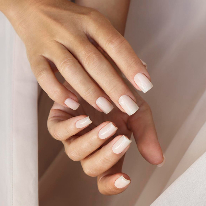 Soft nude-pink nails with white French tips.